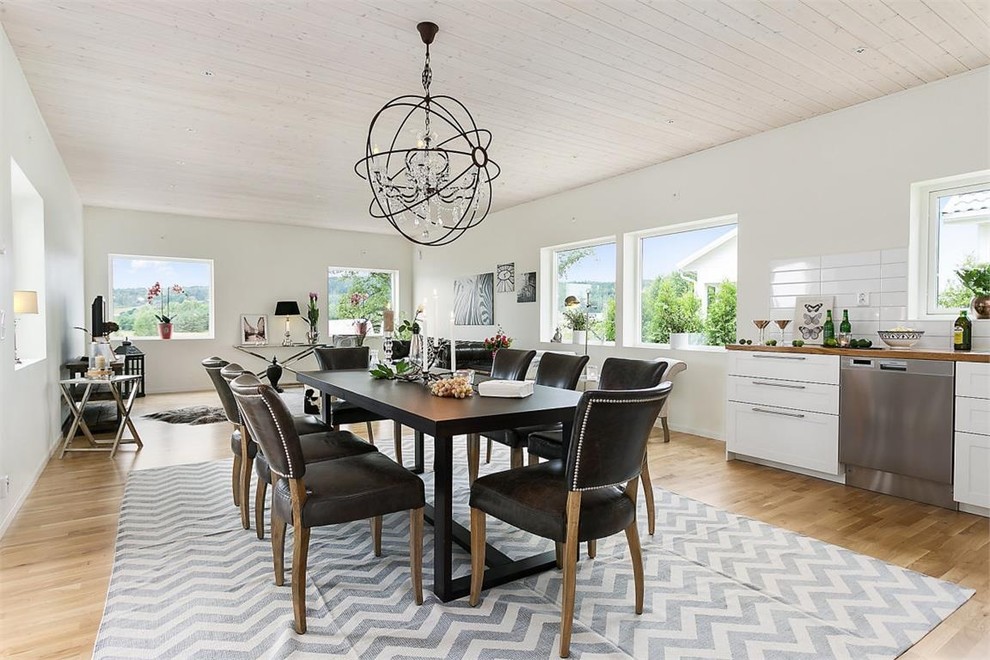 Design ideas for a large eclectic dining room in Gothenburg with white walls, light hardwood flooring and no fireplace.