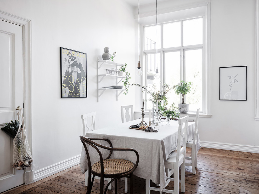 Ispirazione per una sala da pranzo aperta verso la cucina nordica con pareti bianche, pavimento in legno massello medio e pavimento marrone