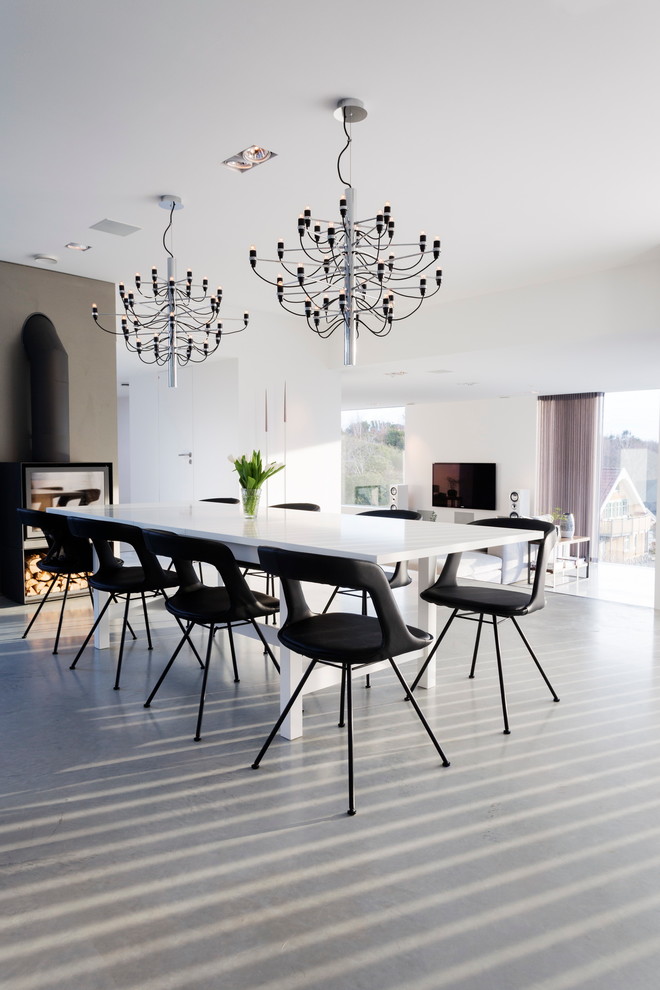 Свежая идея для дизайна: гостиная-столовая среднего размера в стиле модернизм с белыми стенами и бетонным полом без камина - отличное фото интерьера