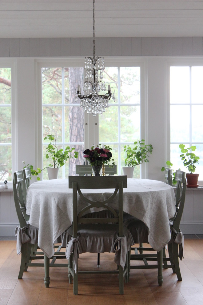 На фото: столовая в классическом стиле с белыми стенами и паркетным полом среднего тона без камина с