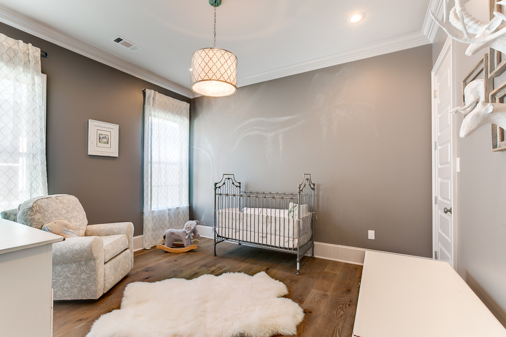 Diseño de habitación de bebé neutra rústica de tamaño medio con paredes grises y suelo de madera clara