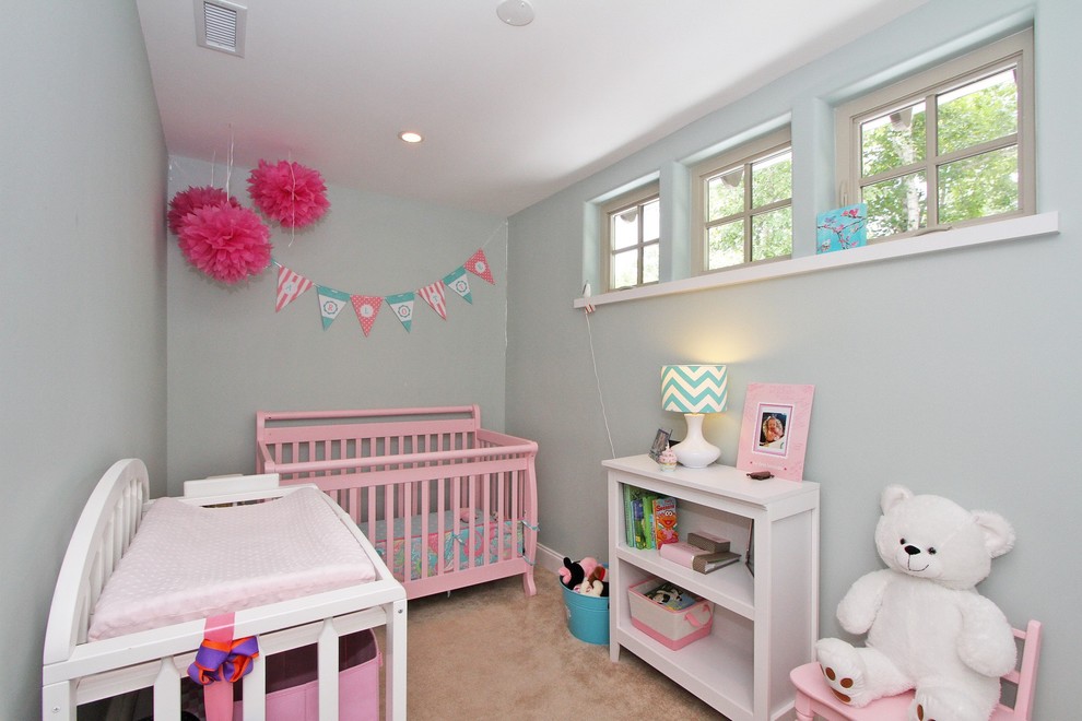 Immagine di una piccola cameretta per neonata tradizionale con pareti grigie e moquette