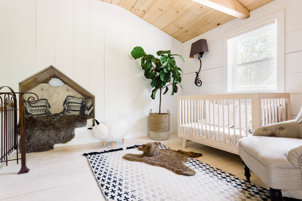 Idées déco pour une petite chambre de bébé neutre campagne avec un mur blanc et parquet clair.