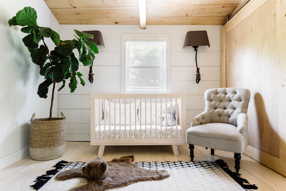 Idee per una piccola cameretta per neonati neutra country con pareti bianche e parquet chiaro