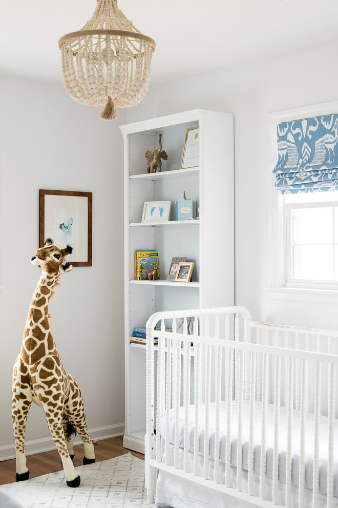 Diseño de habitación de bebé neutra clásica renovada con paredes blancas y suelo de madera oscura