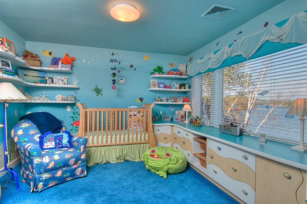 Photo of a nautical nursery for boys in Boston with blue walls and carpet.