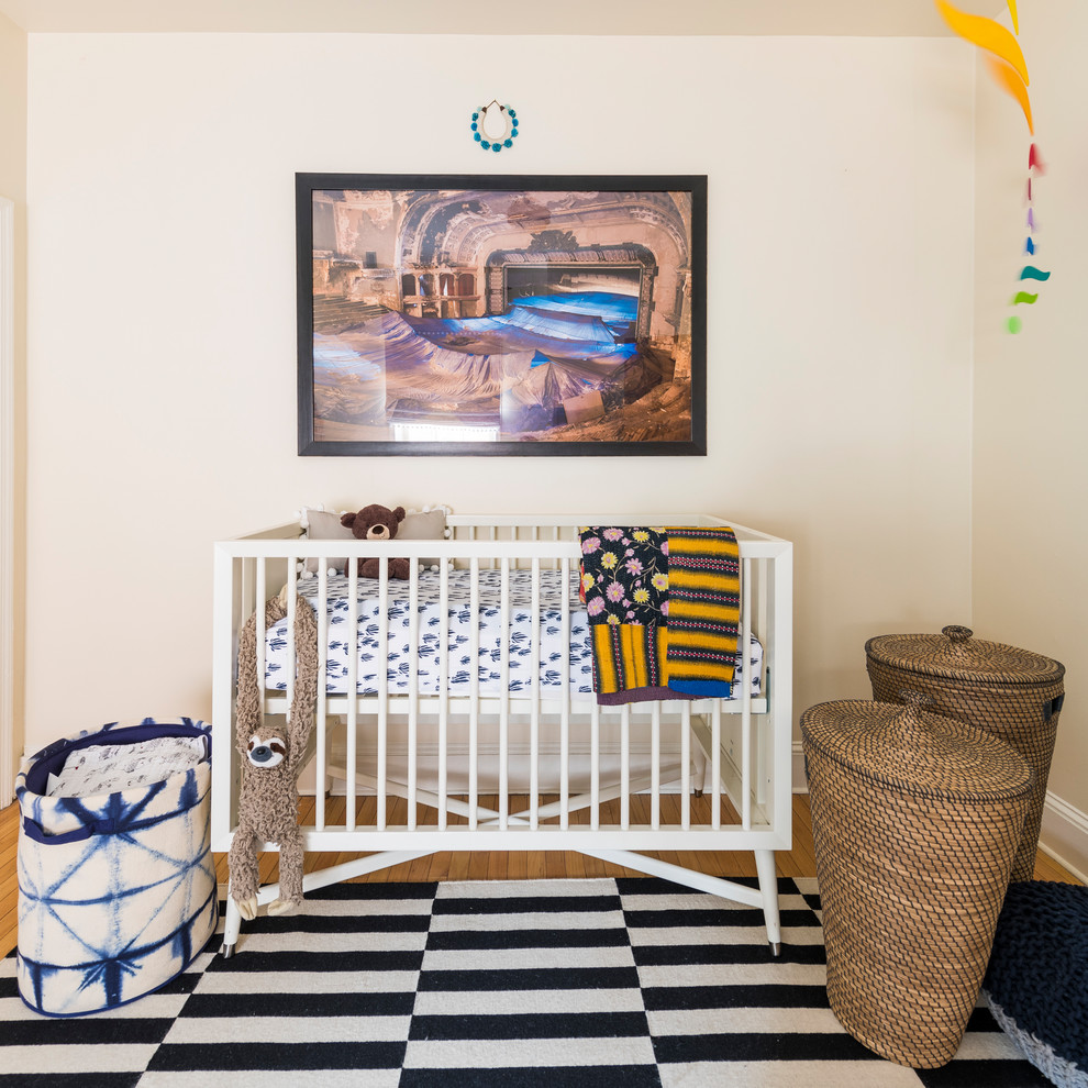 Réalisation d'une chambre de bébé design de taille moyenne avec un mur beige, un sol en bois brun et un sol marron.