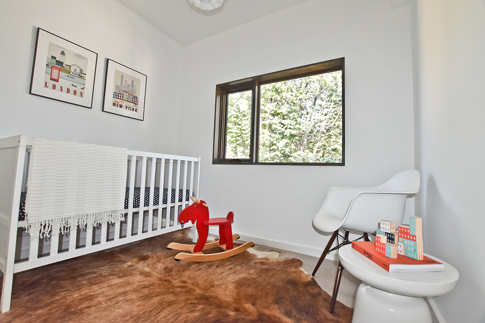 Aménagement d'une petite chambre de bébé neutre moderne avec un mur blanc et parquet clair.