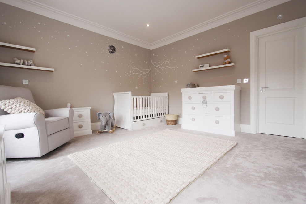 Large trendy gender-neutral carpeted and gray floor nursery photo in Surrey with beige walls