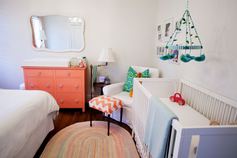 Diseño de habitación de bebé niña ecléctica de tamaño medio con paredes blancas y suelo de madera oscura