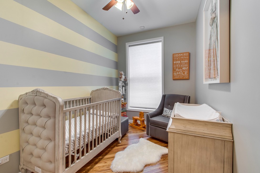 Inspiration for a small transitional gender-neutral medium tone wood floor nursery remodel in Chicago with gray walls