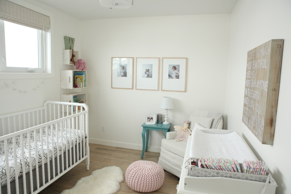 Cette photo montre une chambre de bébé neutre chic de taille moyenne avec un mur blanc, un sol en vinyl et un sol marron.