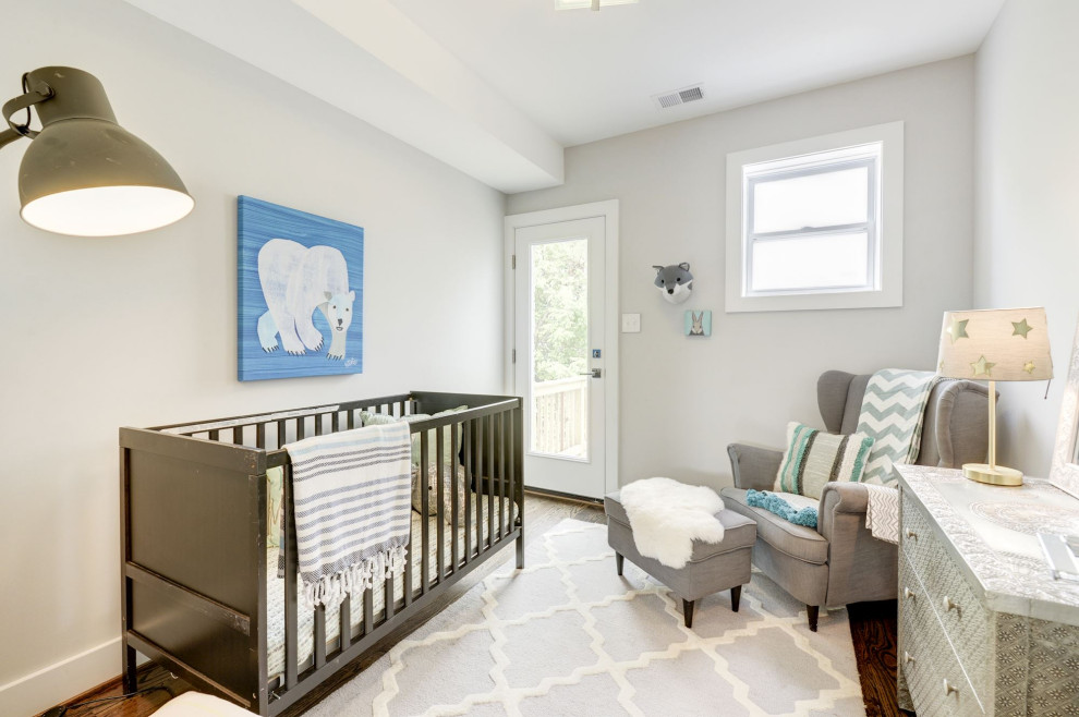 Exemple d'une chambre de bébé neutre chic avec un mur blanc, un sol en bois brun et un sol marron.