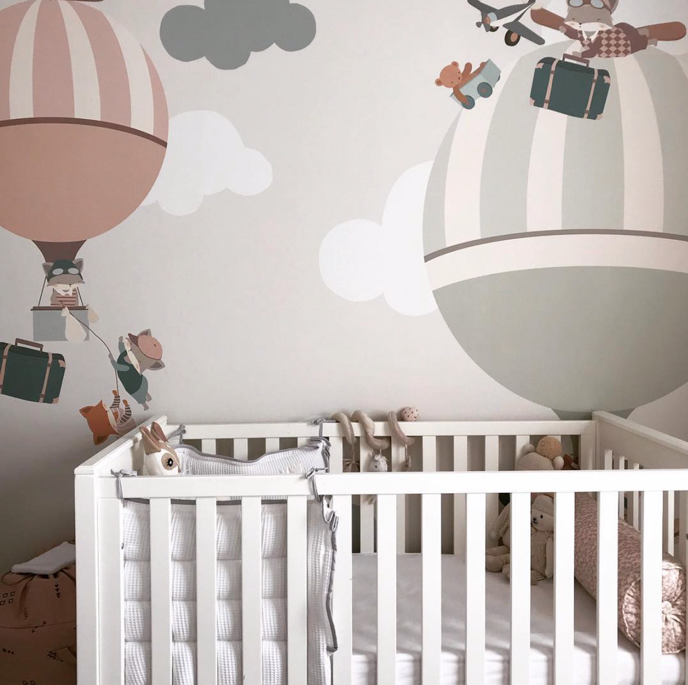 This is an example of a medium sized contemporary nursery for girls in London with multi-coloured walls, carpet and grey floors.