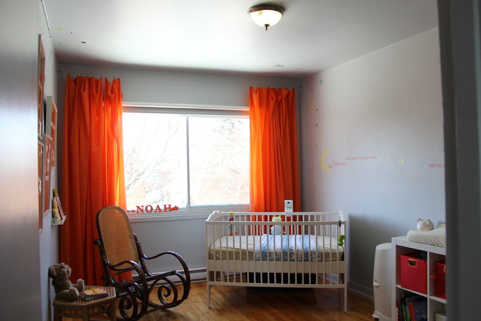 Inspiration for a mid-sized contemporary boy medium tone wood floor nursery remodel in Montreal with gray walls