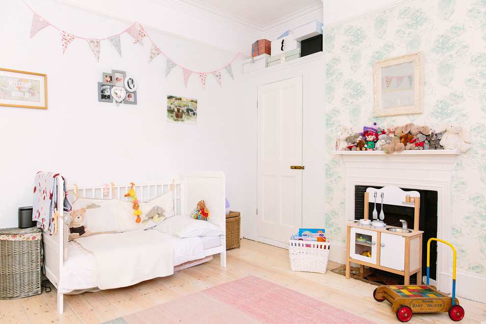 Photo of a medium sized classic nursery in London with grey walls, light hardwood flooring, beige floors and a chimney breast.