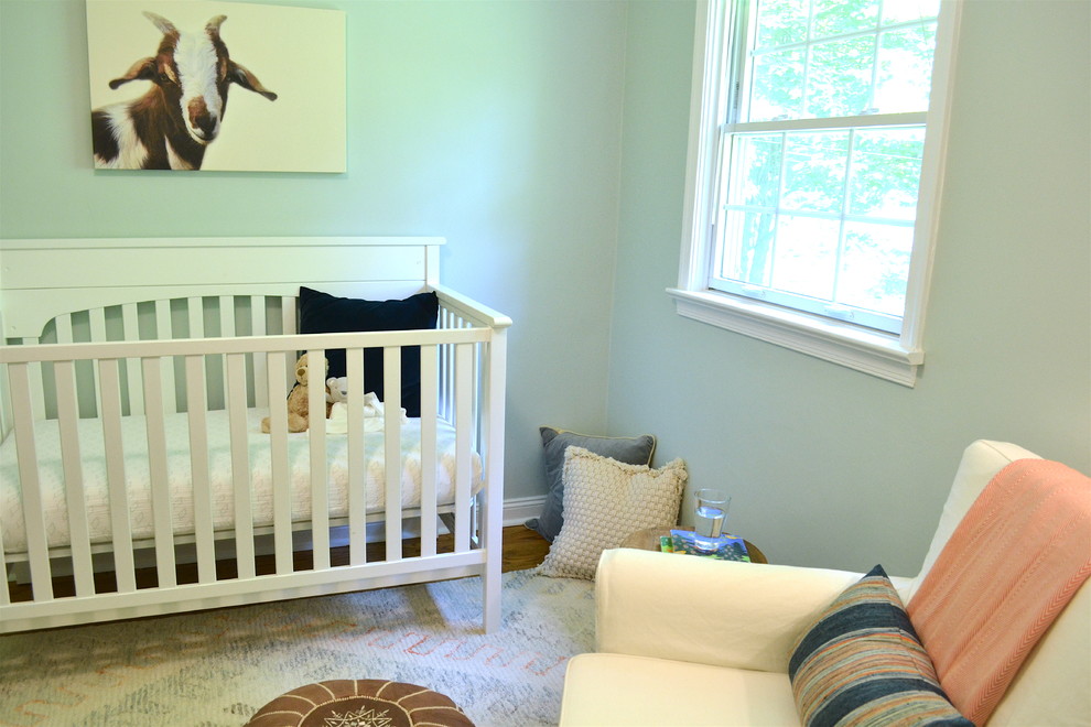 Exemple d'une petite chambre de bébé garçon chic avec un mur bleu et un sol en bois brun.
