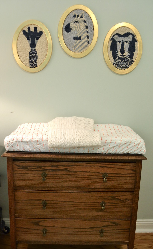 Ejemplo de habitación de bebé niño clásica renovada pequeña con paredes azules y suelo de madera en tonos medios
