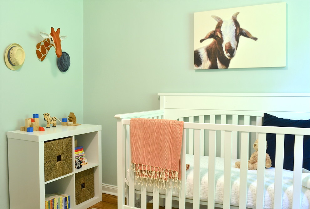 Idee per una piccola cameretta per neonato tradizionale con pareti blu e pavimento in legno massello medio