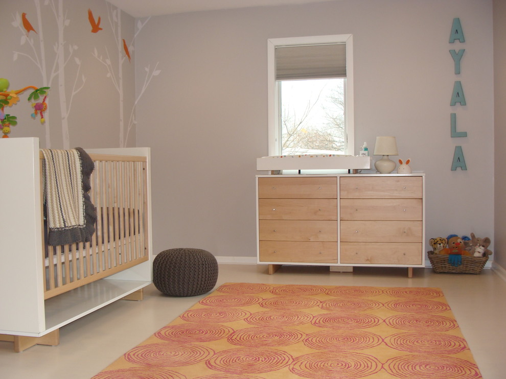 Cette image montre une chambre de bébé neutre nordique avec un mur gris.