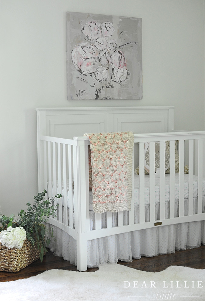 Inspiration pour une chambre de bébé fille traditionnelle avec un mur blanc, parquet foncé et un sol marron.