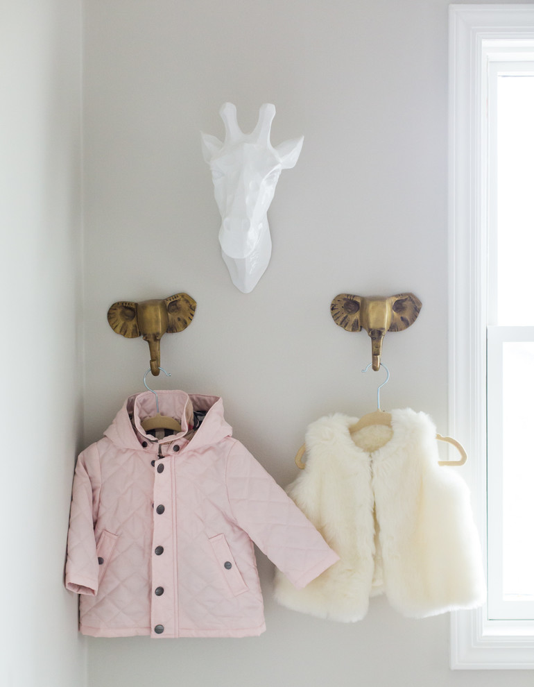 Modelo de habitación de bebé niña minimalista de tamaño medio con paredes grises y suelo de madera en tonos medios