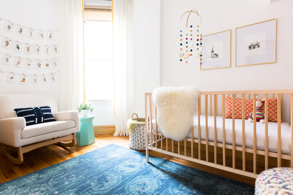 シカゴにある中くらいな北欧スタイルのおしゃれな赤ちゃん部屋 (白い壁、無垢フローリング、男女兼用) の写真