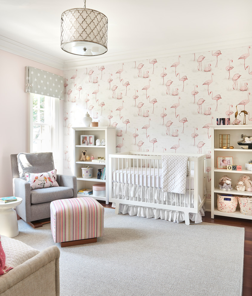This is an example of a medium sized classic nursery for girls in Toronto with pink walls, medium hardwood flooring, brown floors and a feature wall.