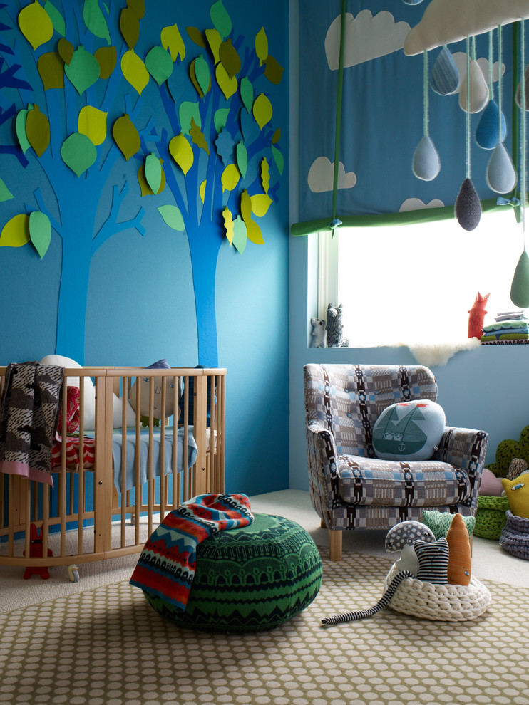 Example of a trendy carpeted nursery design in Hampshire with blue walls