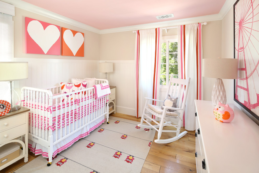 Design ideas for a classic nursery for girls in San Francisco with beige walls and light hardwood flooring.