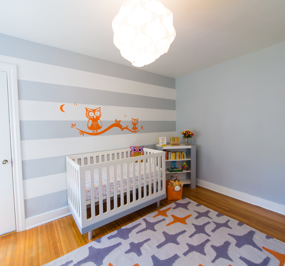Cette image montre une chambre de bébé garçon design avec un mur gris.