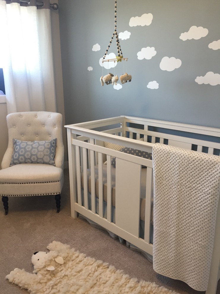 Modelo de habitación de bebé neutra contemporánea de tamaño medio con paredes azules y moqueta