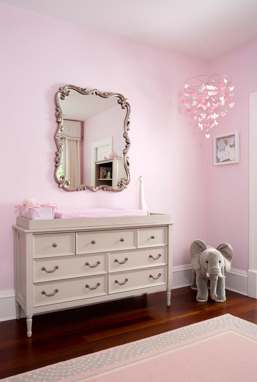 Design ideas for a medium sized classic nursery for girls in DC Metro with pink walls and dark hardwood flooring.
