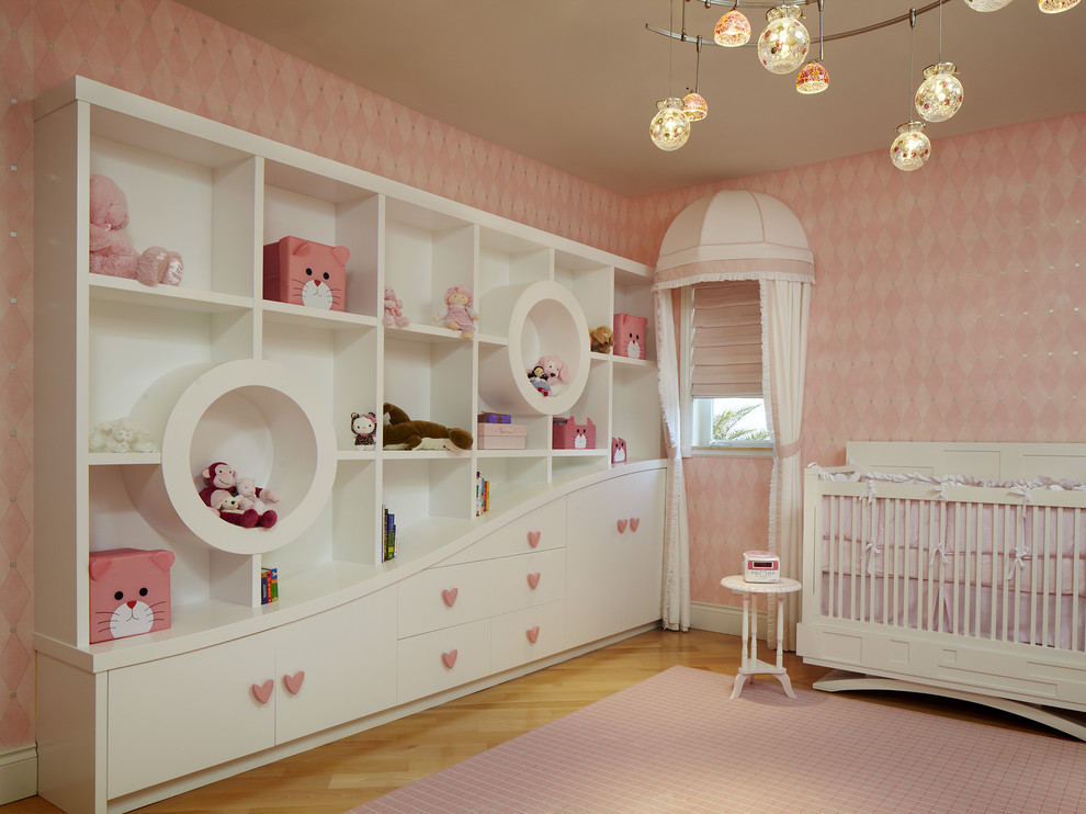 Inspiration för stora moderna babyrum, med rosa väggar och ljust trägolv