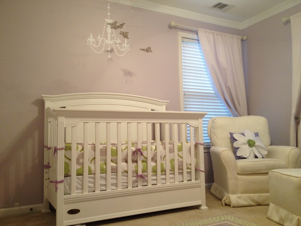 Aménagement d'une petite chambre de bébé fille romantique avec un mur violet et moquette.