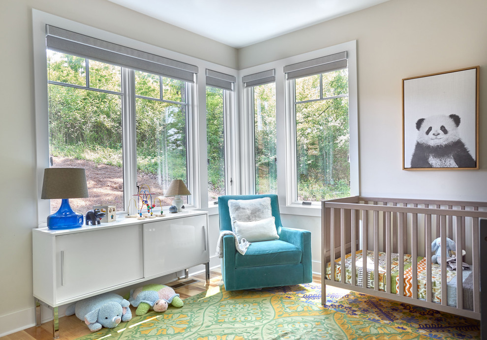 Ejemplo de habitación de bebé neutra contemporánea de tamaño medio con suelo de madera clara