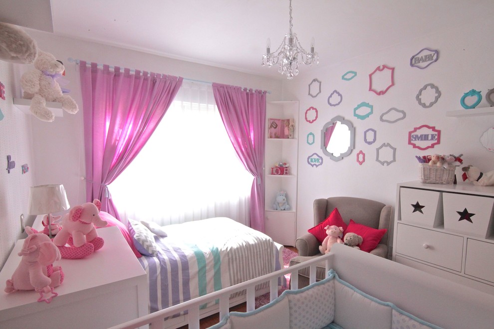 Small eclectic nursery for girls in Mexico City with white walls.