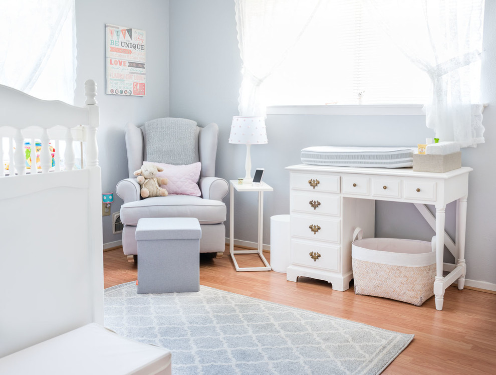 Modelo de habitación de bebé niña clásica con paredes grises y suelo de madera clara
