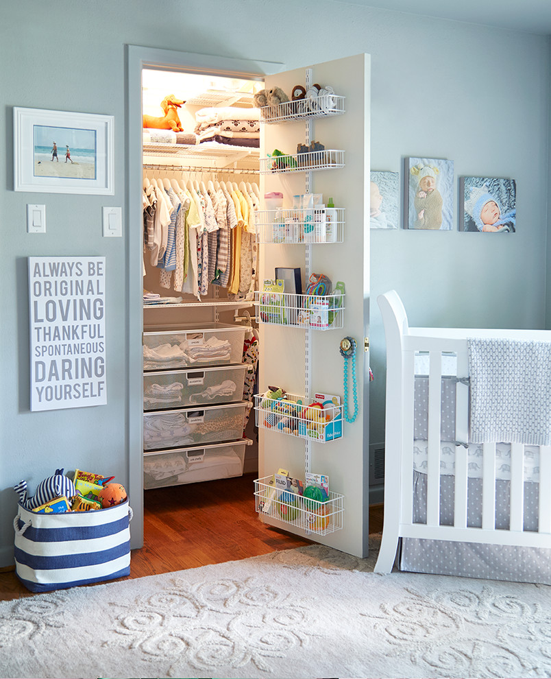 Esempio di una cameretta per neonato chic con pareti blu e pavimento in legno massello medio