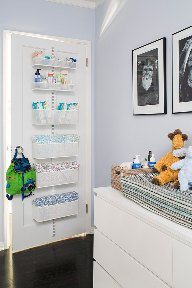 Ejemplo de habitación de bebé niño clásica renovada con paredes azules y suelo de madera oscura