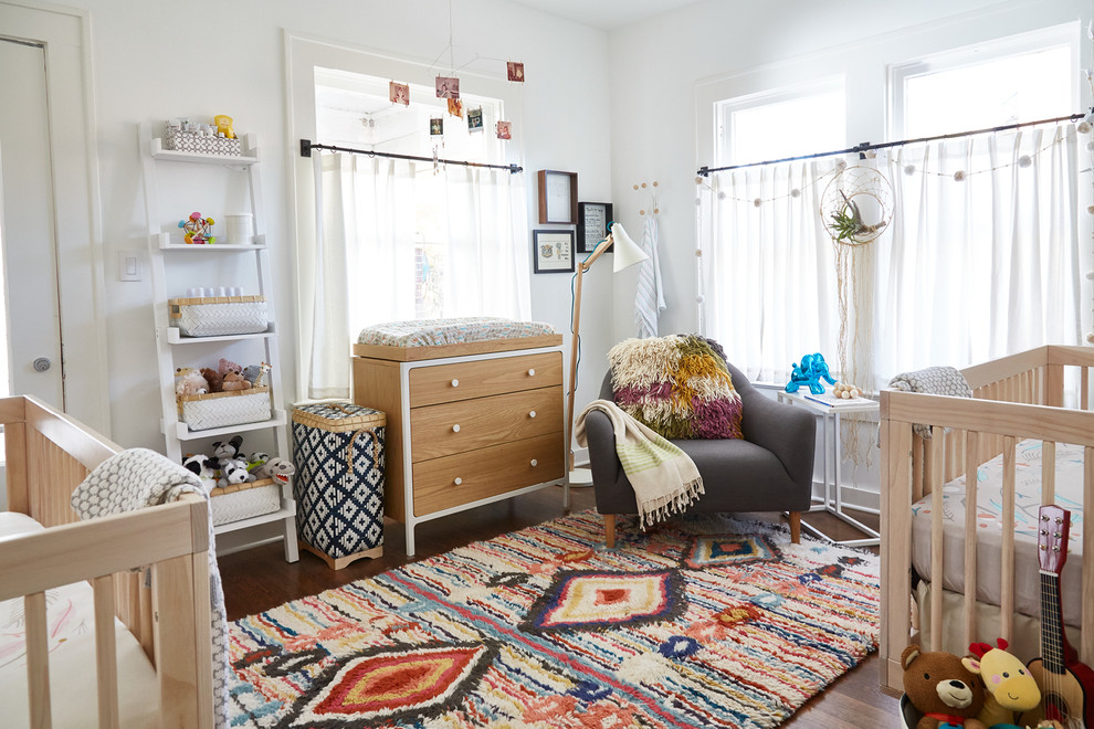Ejemplo de habitación de bebé neutra tradicional renovada con paredes blancas y suelo de madera en tonos medios