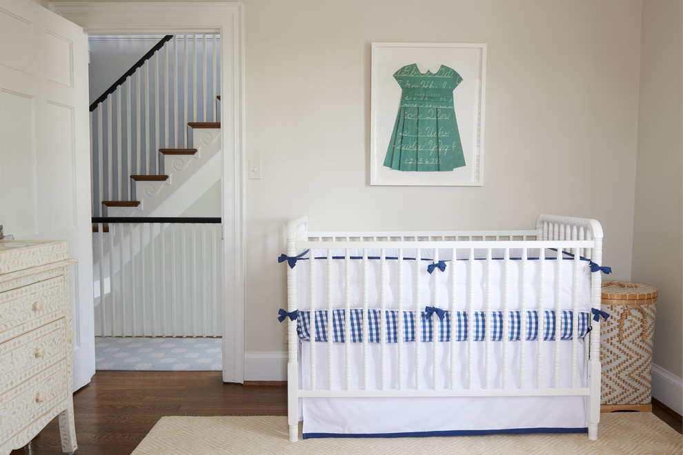Ejemplo de habitación de bebé niña actual con paredes beige y suelo de madera oscura
