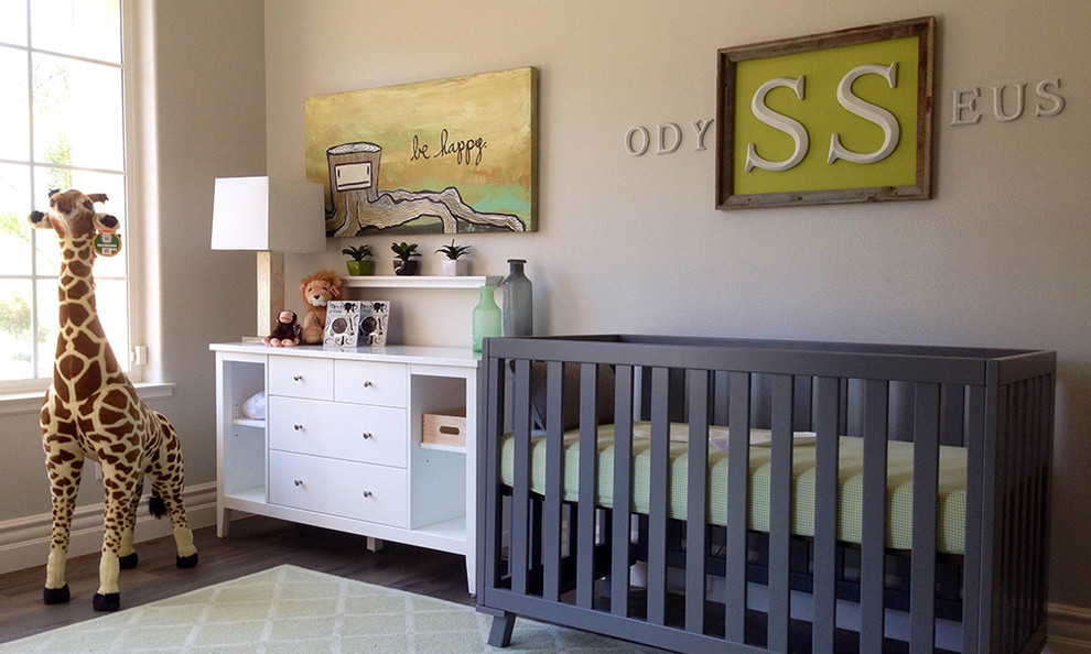 Cette photo montre une chambre de bébé neutre rétro de taille moyenne avec un mur beige et un sol en bois brun.