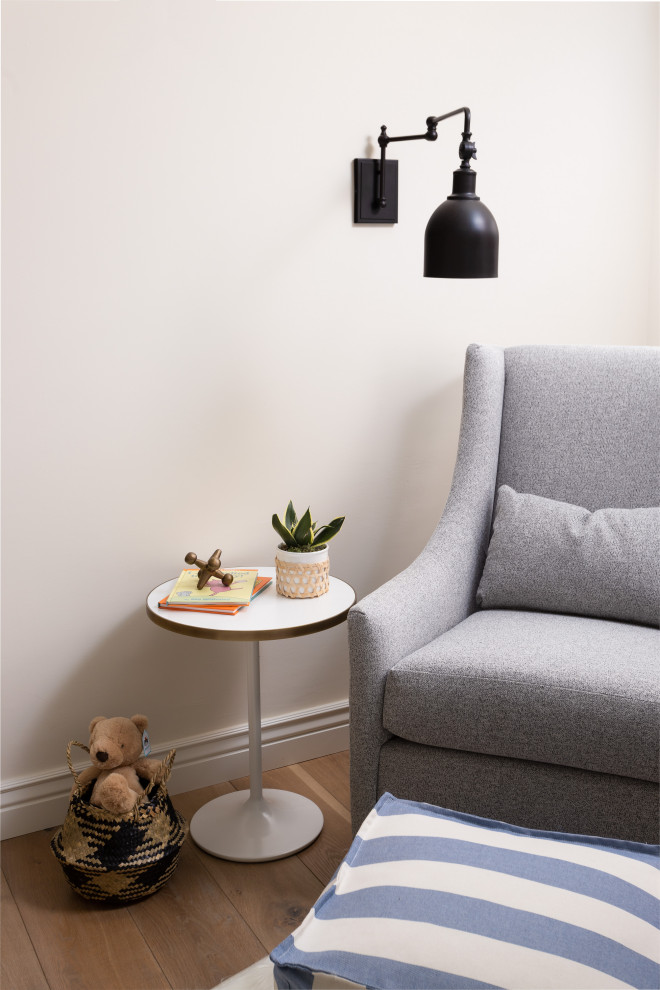 Idée de décoration pour une chambre de bébé garçon minimaliste de taille moyenne avec un mur bleu, parquet clair et un sol marron.