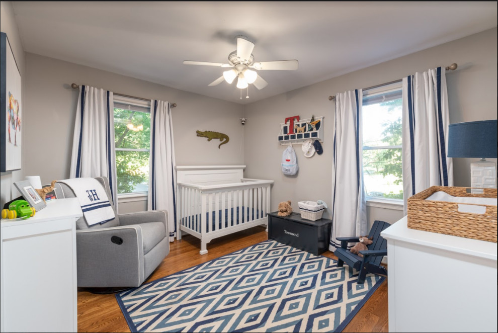 Inspiration for a classic nursery for boys in Charlotte with grey walls, medium hardwood flooring and brown floors.