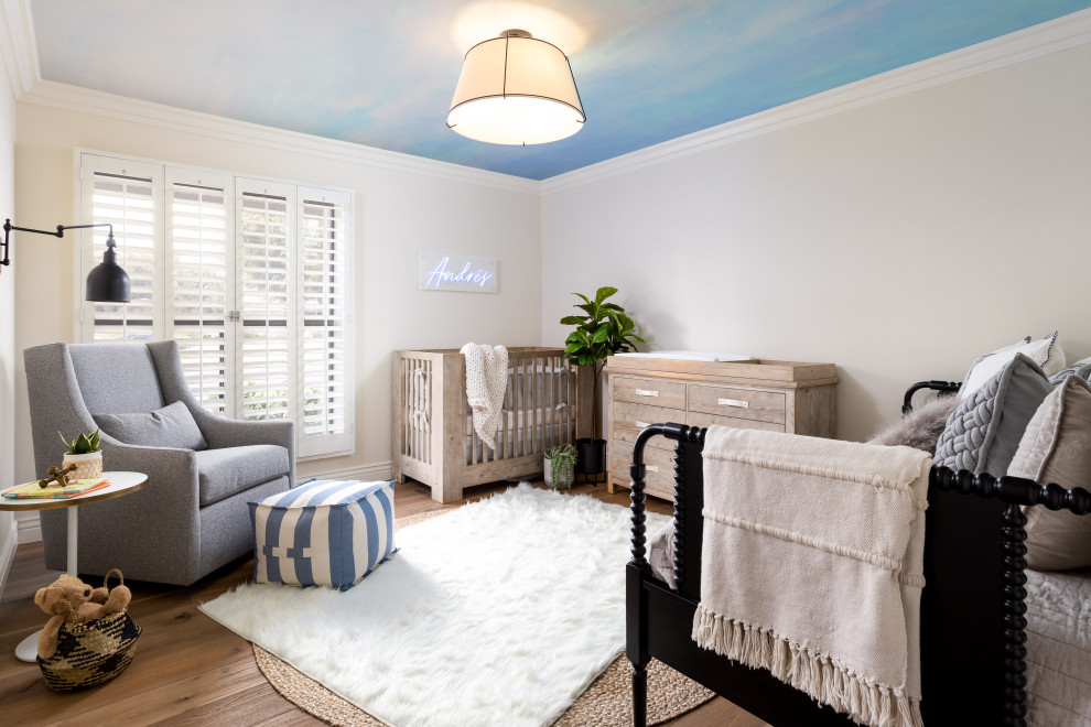 Immagine di una cameretta per neonato classica di medie dimensioni con pareti blu, parquet chiaro e pavimento marrone