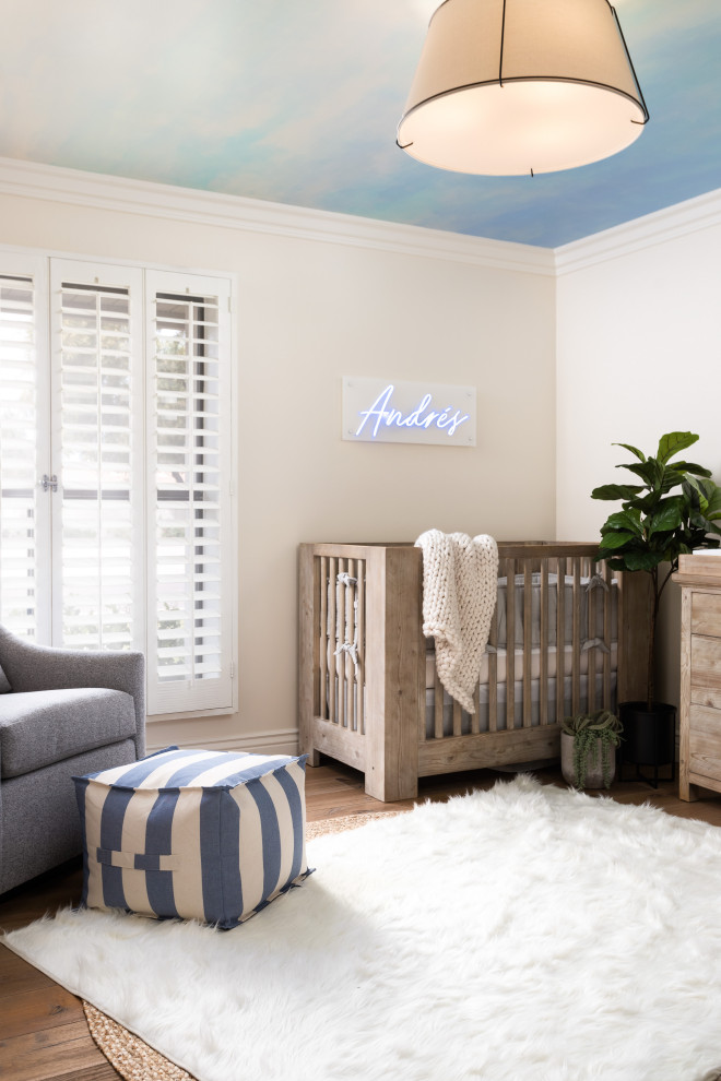 Modern inredning av ett mellanstort babyrum, med blå väggar, ljust trägolv och brunt golv
