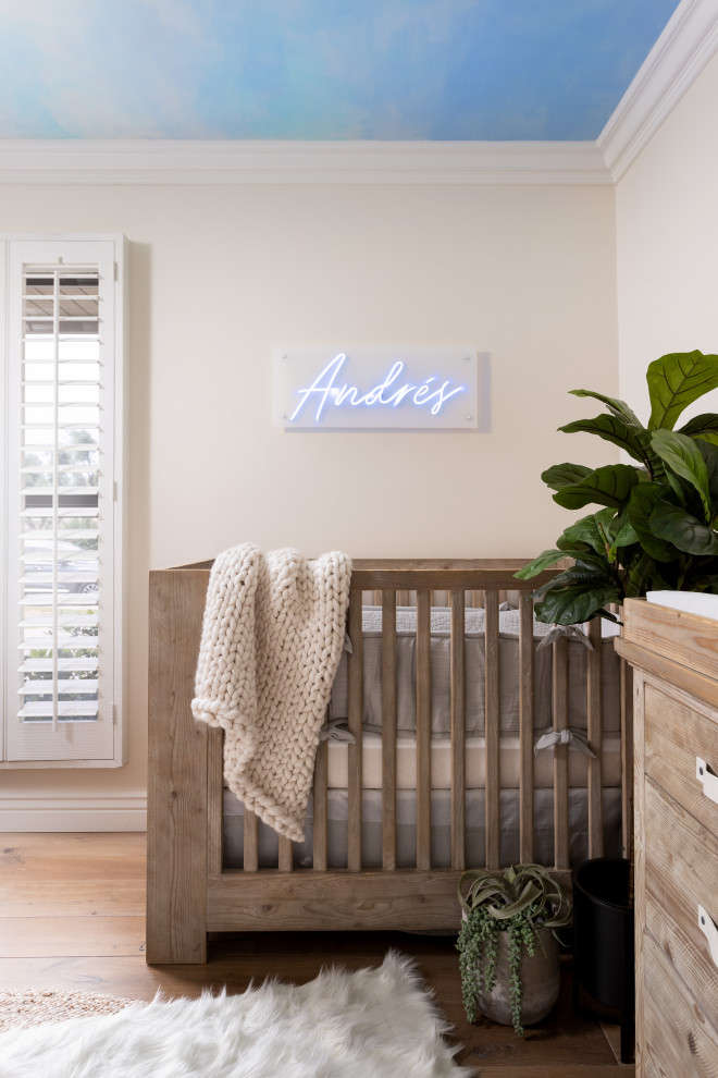 Idee per una cameretta per neonato minimalista di medie dimensioni con pareti blu, parquet chiaro e pavimento marrone
