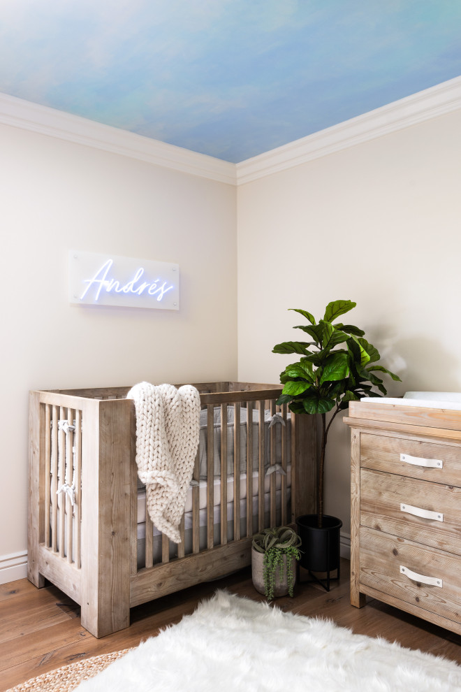 Ispirazione per una cameretta per neonato minimalista di medie dimensioni con pareti blu, parquet chiaro e pavimento marrone