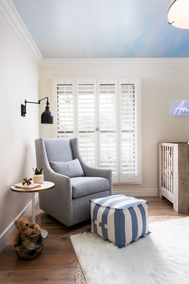 Exemple d'une chambre de bébé garçon moderne de taille moyenne avec un mur bleu, parquet clair et un sol marron.